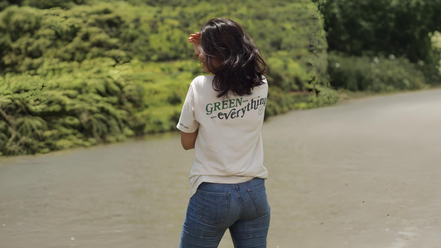 erson wearing One Less GOTS-certified organic cotton t-shirt and shorts standing in monsoon rain, showing breathable sustainable fabric for humid weather