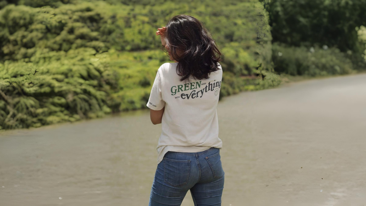 erson wearing One Less GOTS-certified organic cotton t-shirt and shorts standing in monsoon rain, showing breathable sustainable fabric for humid weather