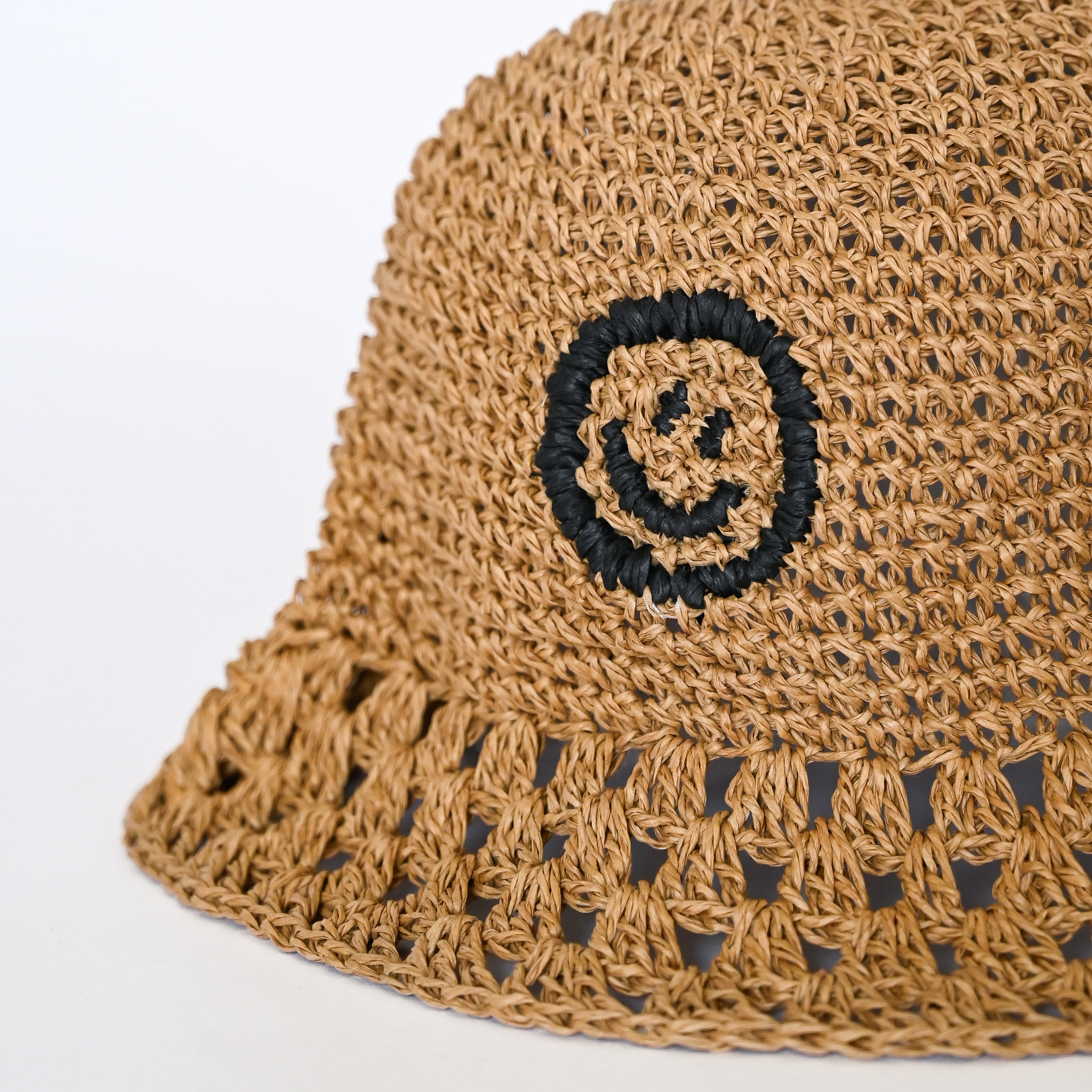 Raffia Bucket Hat in Coal black with signature OL smiley, front view