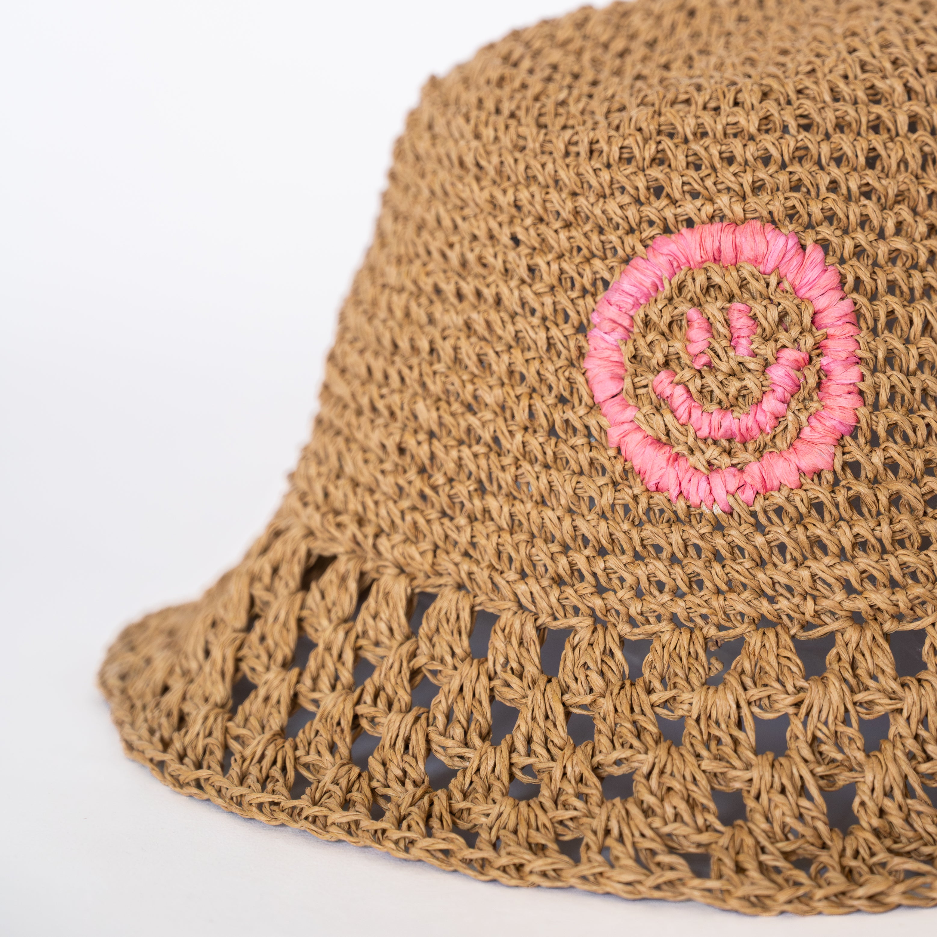 Raffia Bucket Hat in Dusty Pink with signature OL smiley, front view